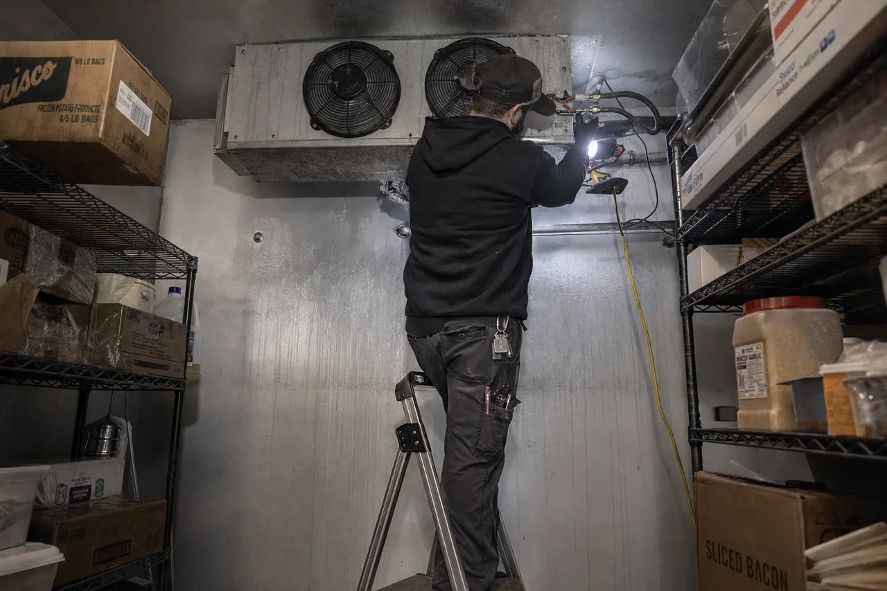 Technician servicing a walk-in cooler